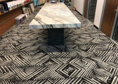 Black and white carpet under a marble conference table