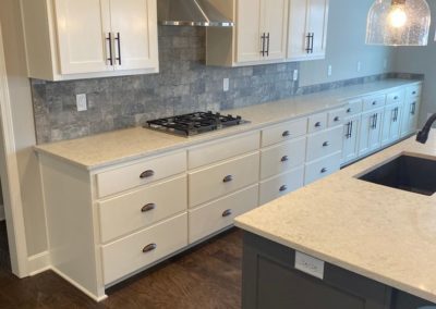 White wood cabinets with modern countertop and silver appliances designed and installed by MAC