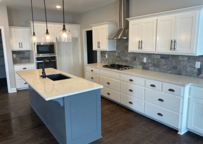 White wood cabinets with modern countertop and silver appliances designed and installed by MAC