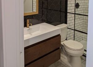 Bath room with glass shower and dark wood cabinets designed by MAC