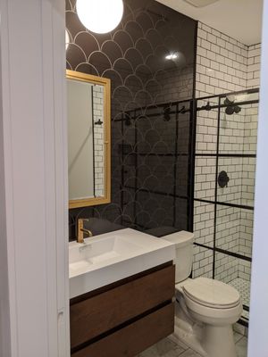 Bath room with glass shower and dark wood cabinets designed by MAC