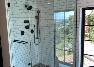 Glass shower with custom black and white tiling installed by MAC in Kansas City
