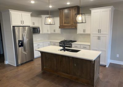 Custom white wood cabinets designed by MAC with marble countertop and silver appliances in Kansas City