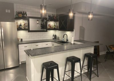 White cabinets installed by MAC with black marble countertops and a wine display in Kansas City